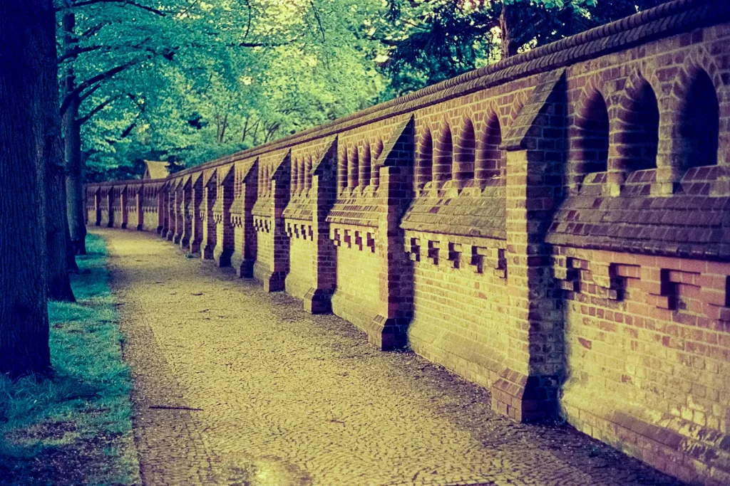 brick wall surrounding the Engesohde cemetery in Hannover, shot on CineStill 800t film with an orange filter