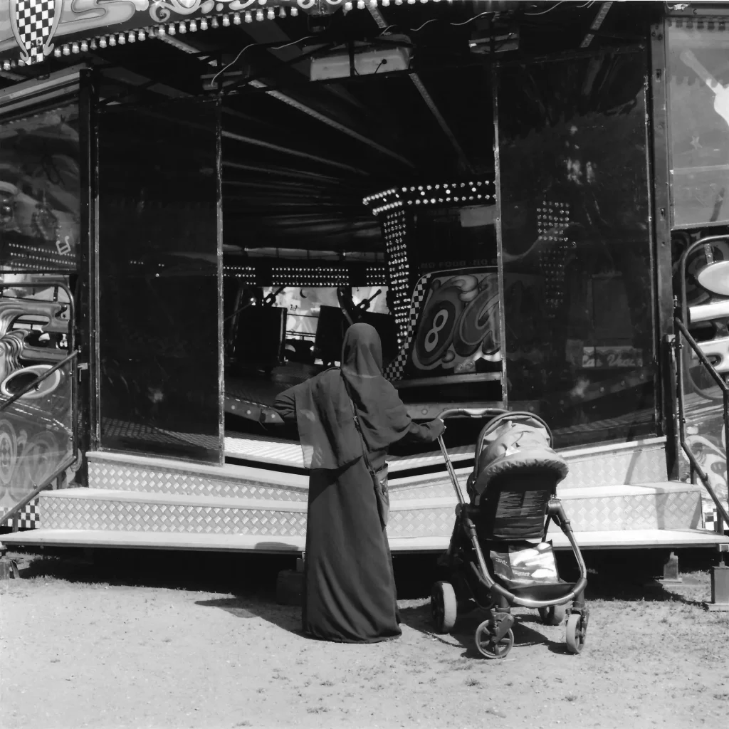 Woman with Pram at Fairground. 