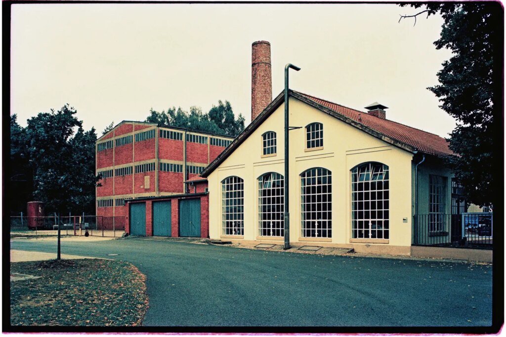 Two old industrial buildings with a chimney between them.