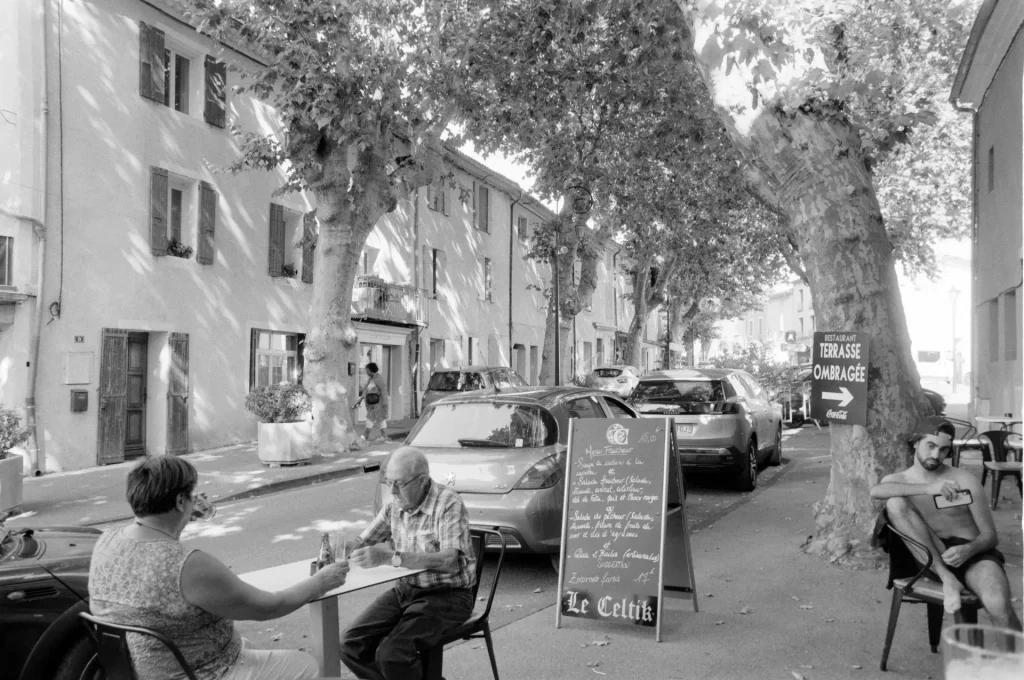 People sitting outside a French village bar