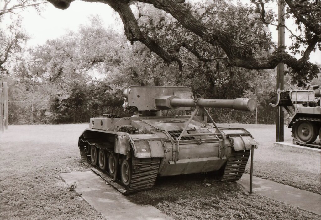 A black and white image of a tank under a tree.