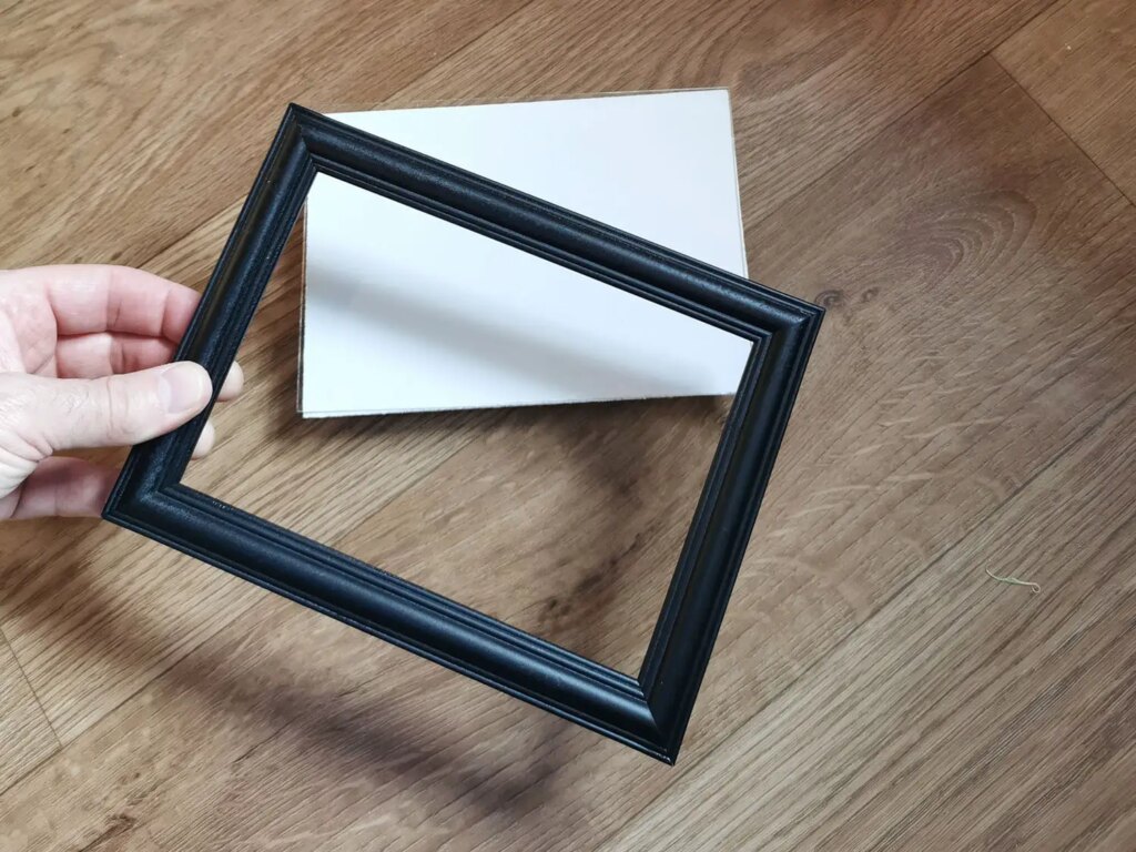 Frame with board standing on surface