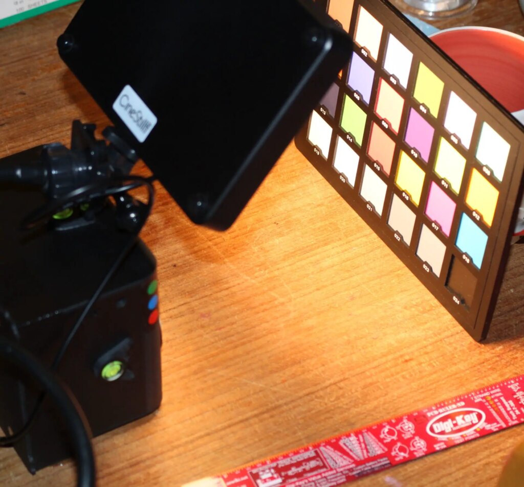 Digital image of a Pinsta camera, a lamp and a colour chart