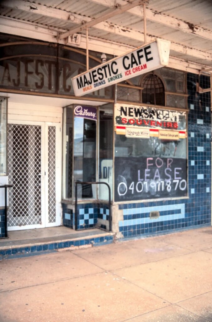 The majestic cafe's faded shop front with a for lease sign in the window
