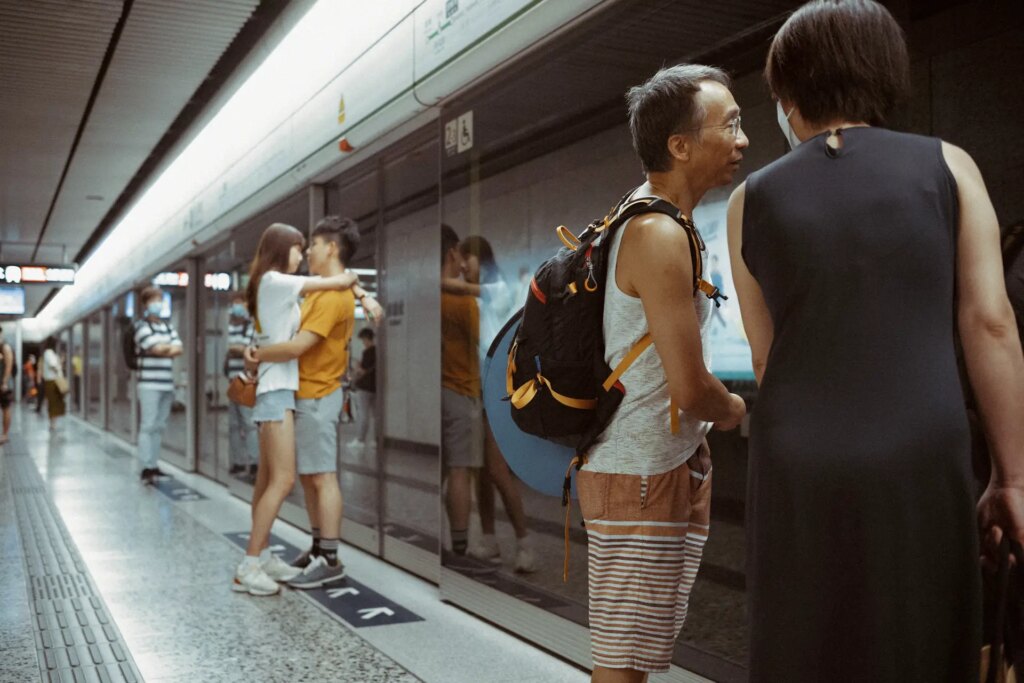 Young couples and old friends in the metro. The reflection of the couple fill the center of the image and also showing the facial expression of the girl better