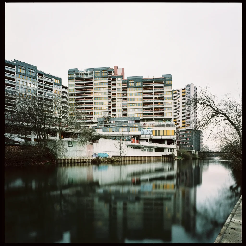 Large apartment buildings with a river in the foreground.