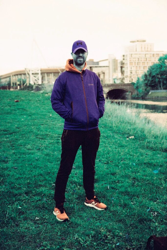 portrait of man standing on grass next to river taken on Lomography Turquoise