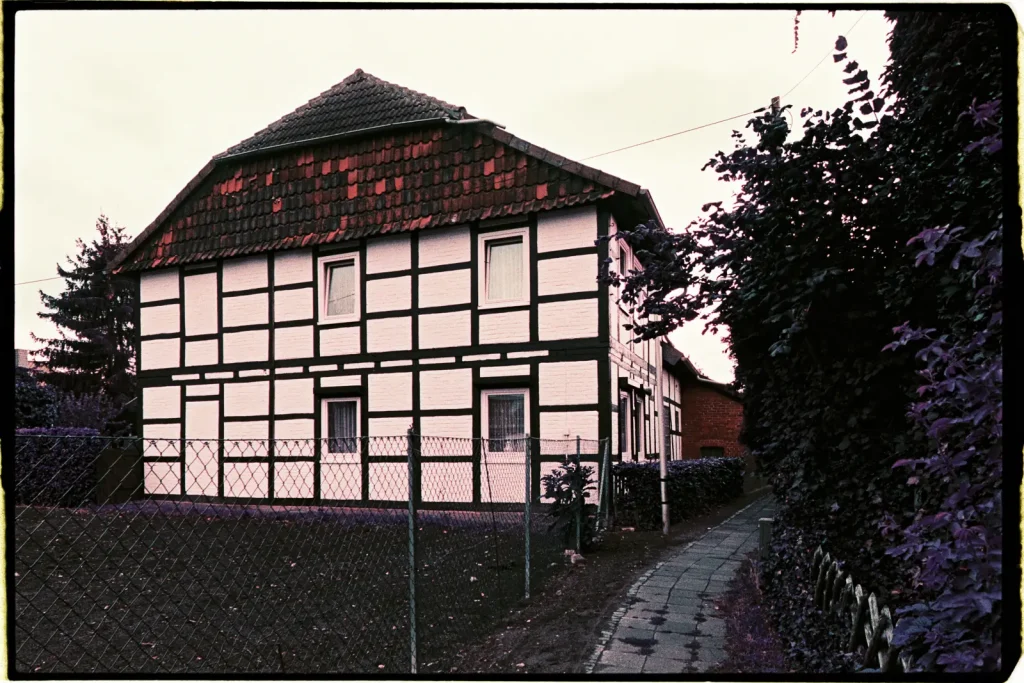 Half-timbered house at dusk, captured on Lomography Purple film.