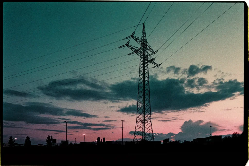 Power pole standing against a colorful sky at sunset, captured on Lomography Purple.