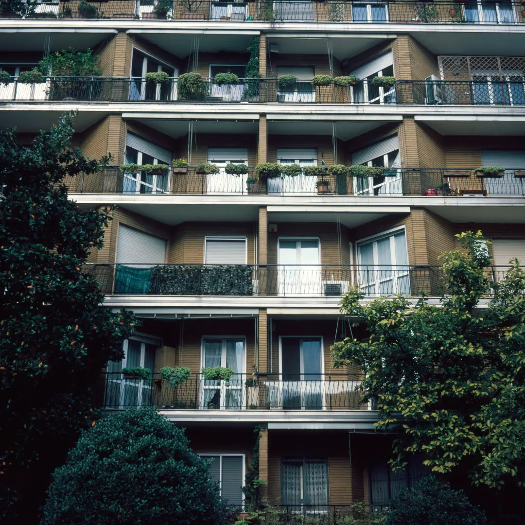 Building full with plants on every floor, surrounded by trees.