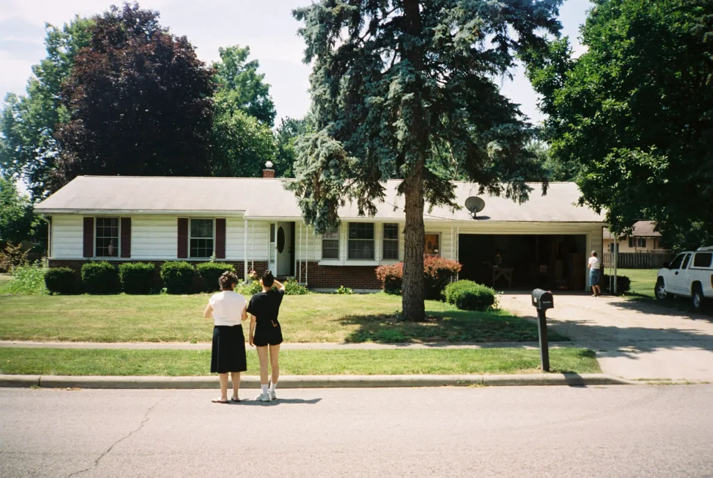 Minolta AF 35R QD photo of two women standing in street in front of house