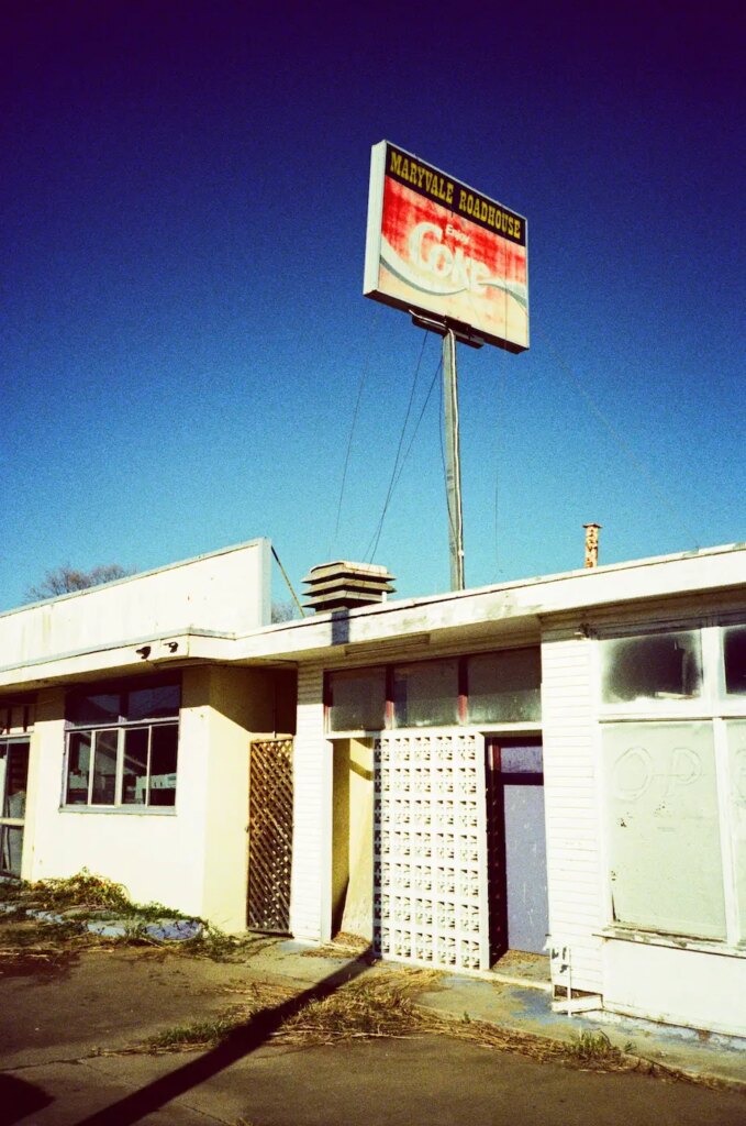 Cross processed image of old building and sign in bright sunlight