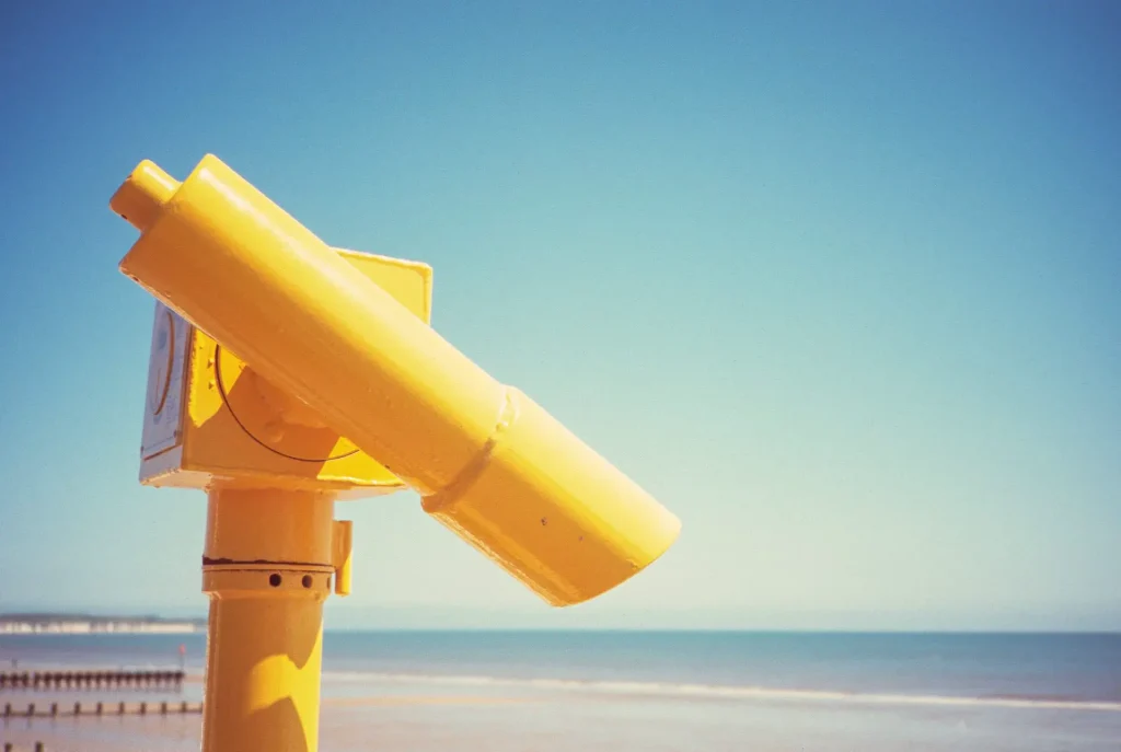 Yellow telescope beside the beach