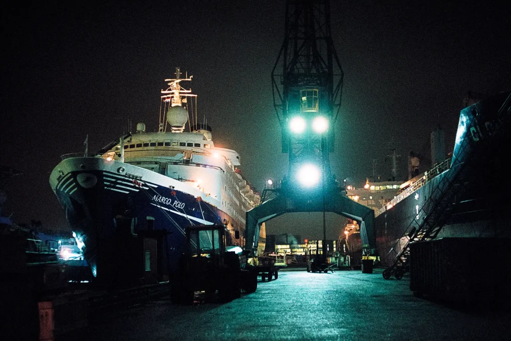 Two ships are getting repaired at a shipyard.