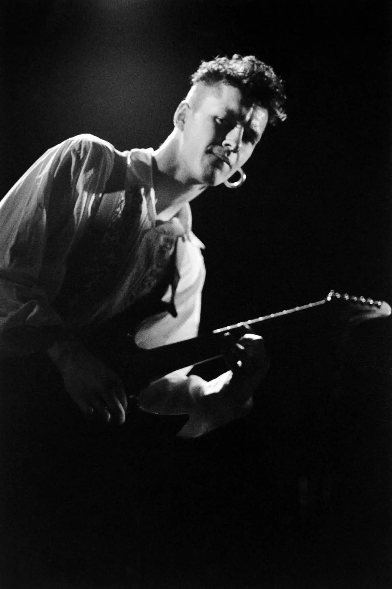 black and white image of a man playing the guitar
