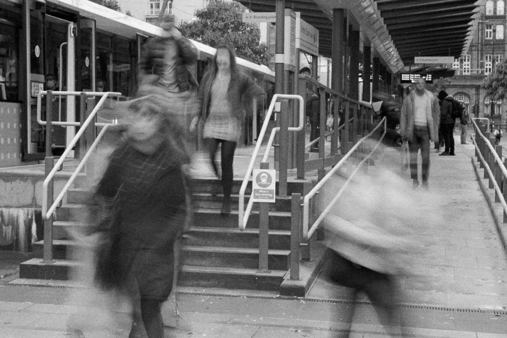 Passengers pass a wear a face covering sign as they leave a tram stop