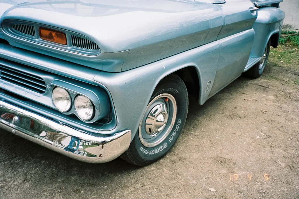 The left front corner of an old American pick-up truck.