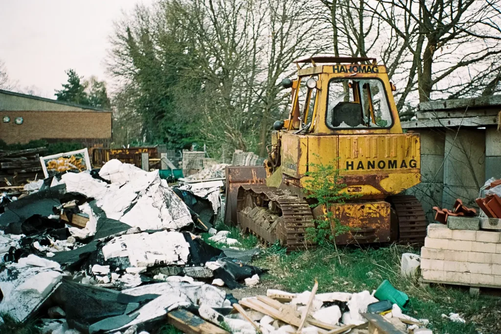 Wreck of a yellow bulldozers standing in a field of debris.