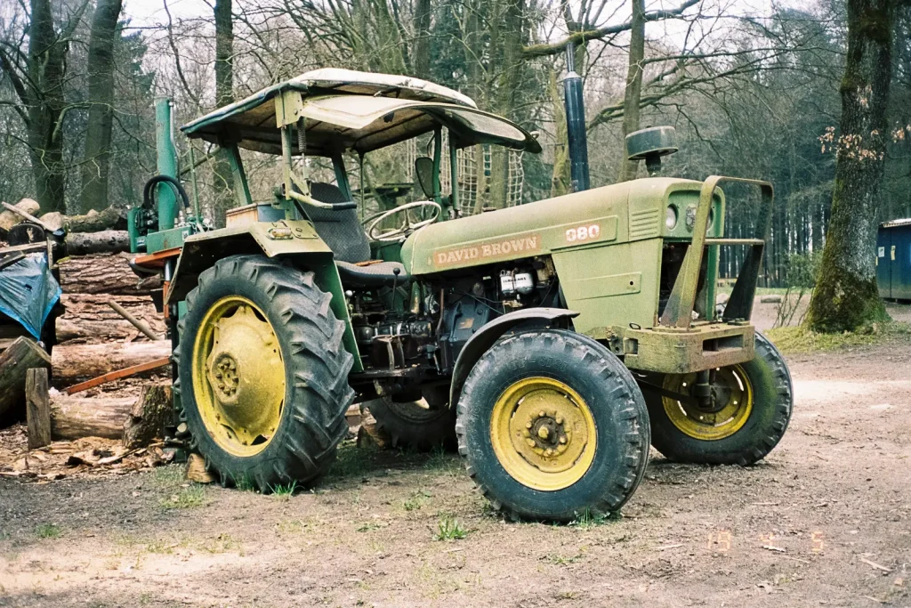 A green old tractor with yellow wheels.