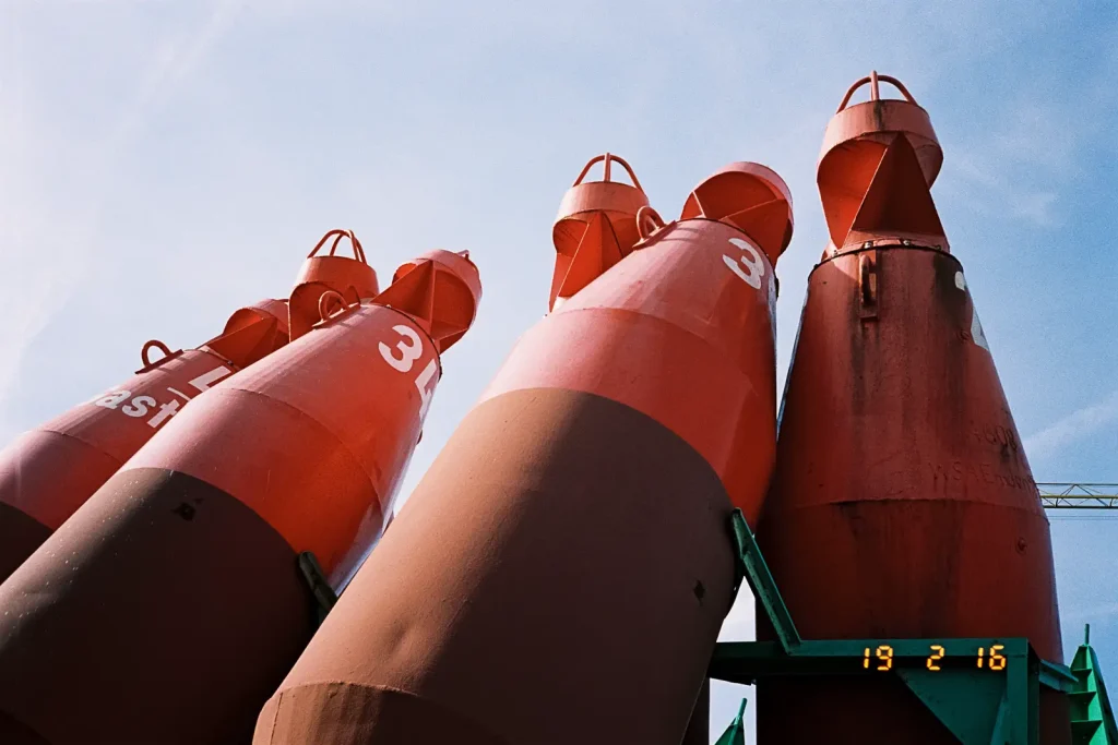 Red buoys leaning against each other.