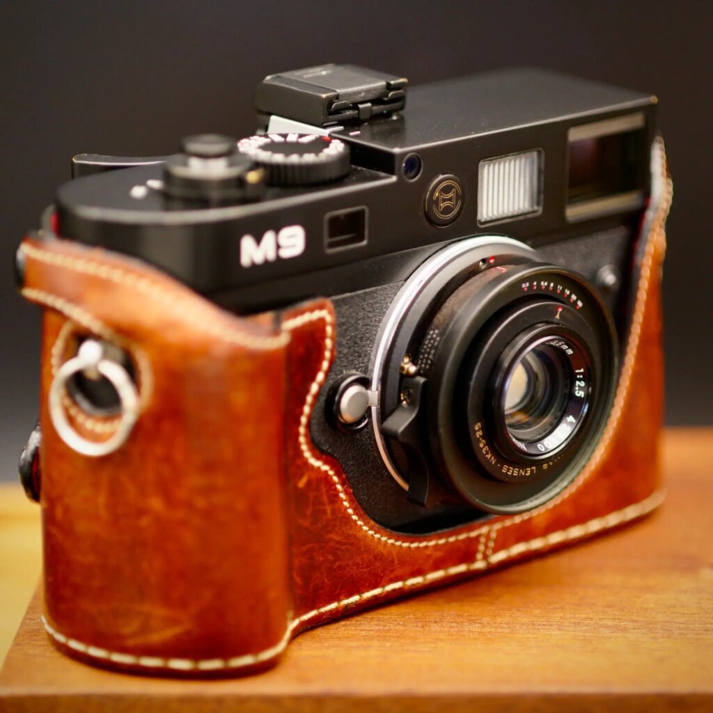 Omnar Lenses NK35-25 lens attached to a Leica M camera shot on wooden table with dark background