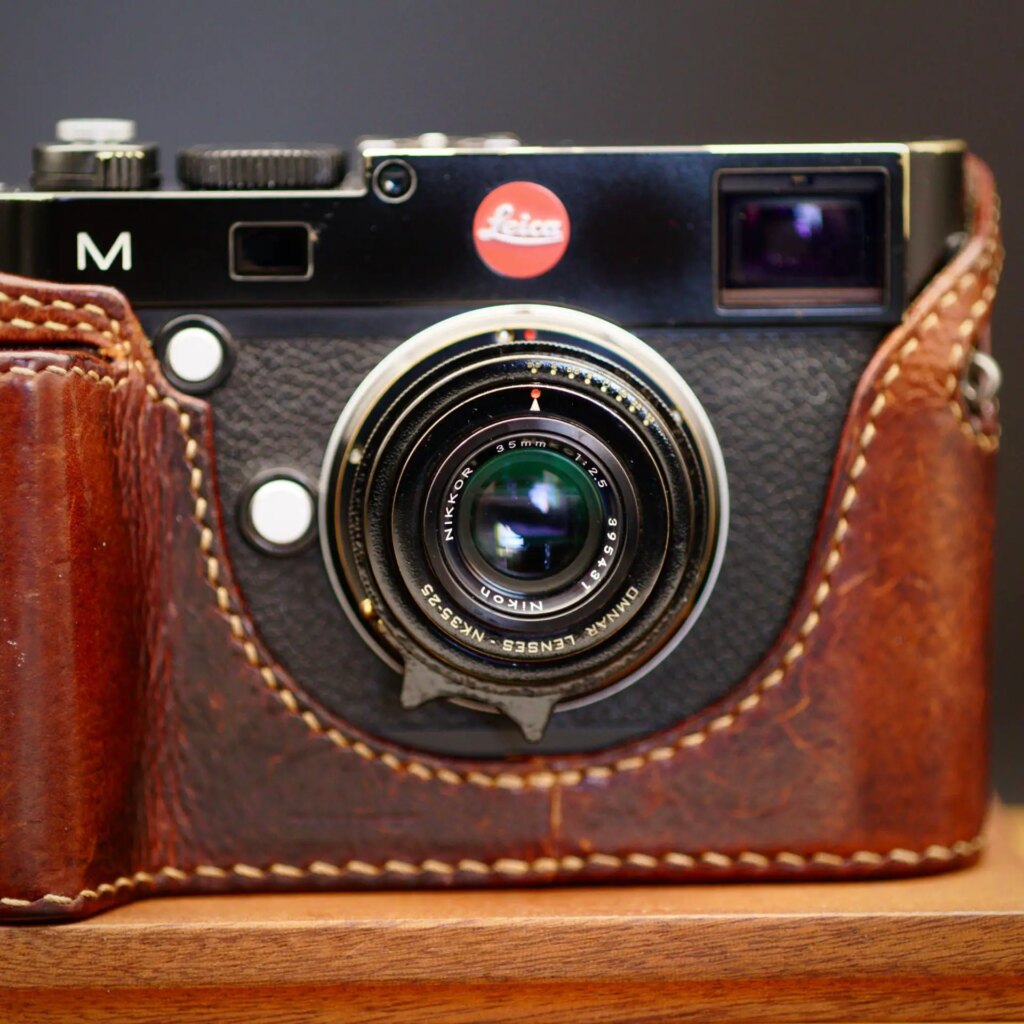 Omnar Lenses NK35-25 lens attached to a Leica M camera shot on wooden table with dark background