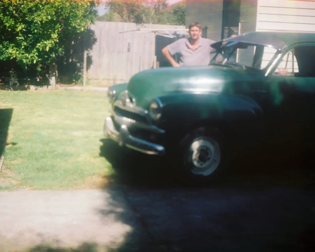 Green Holden FJ with person behind it