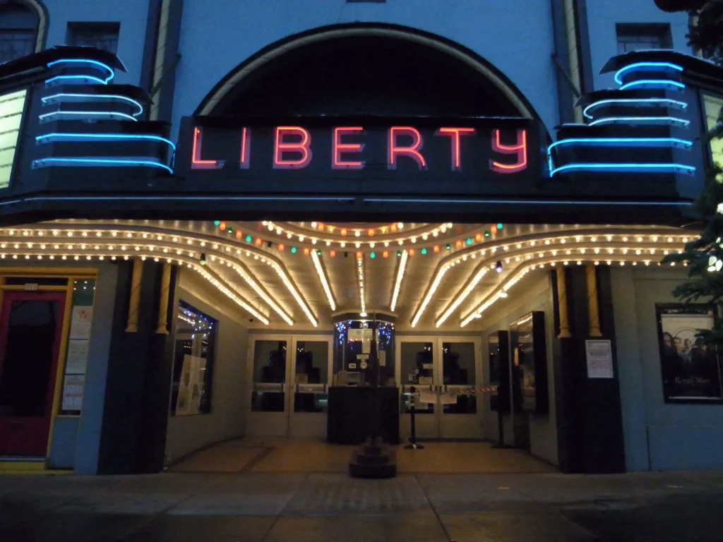 A neon sign denotes the Liberty theater and the entry way ceiling has a radiant pattern of lights. 