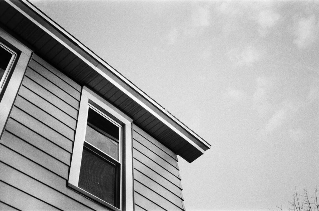 A corner of a house against a cloudy sky