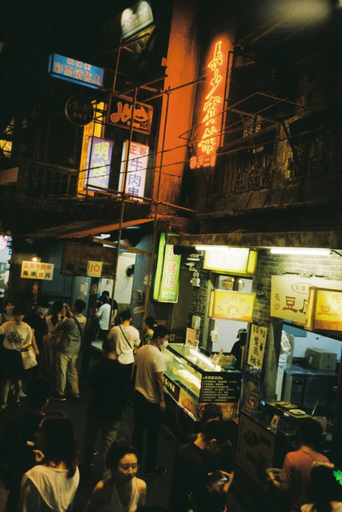 Nightstreet with food shops and neons banners.