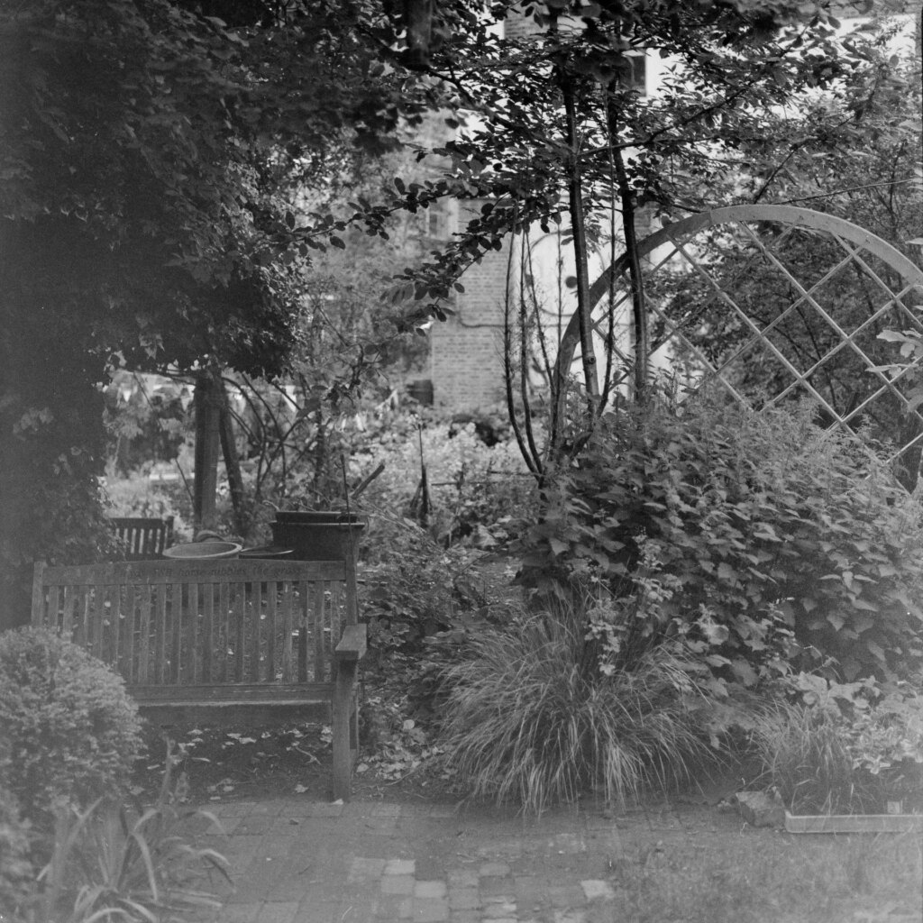 Black and white photo of a bench and wooden globe in the Phoenix Garden