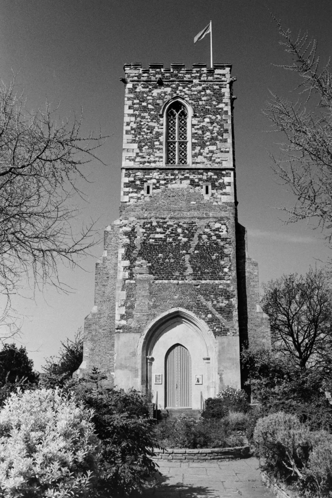 Black and white photograph of Hornsey tower from the front, surrounded by flowerbeds of memorial garden