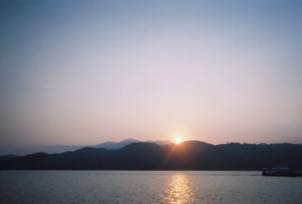 sunrise over the mountains beyond a large body of water