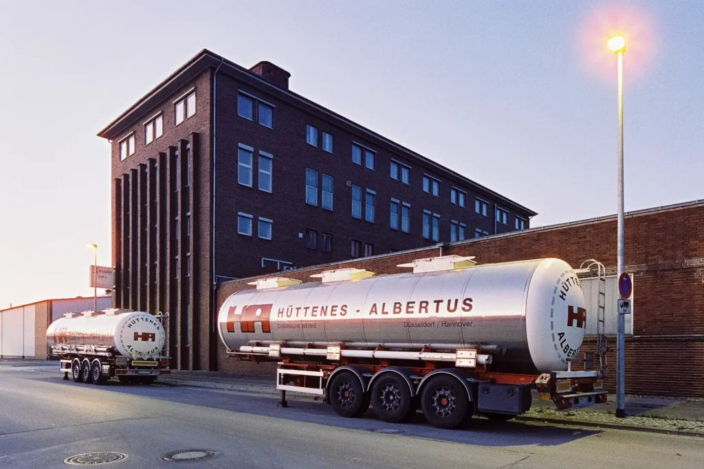 dark brick building with silver tank cars in the foreground, shot at dusk on CineStill film