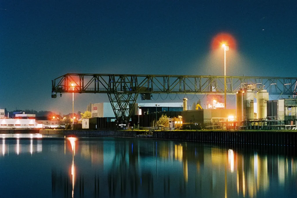 inland harbor with loading cranes shot at night on CineStill film