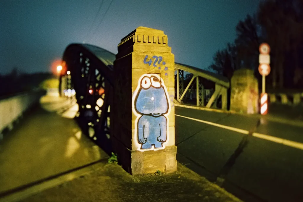 Graffiti on a bridge pylon shot at night on CineStill film
