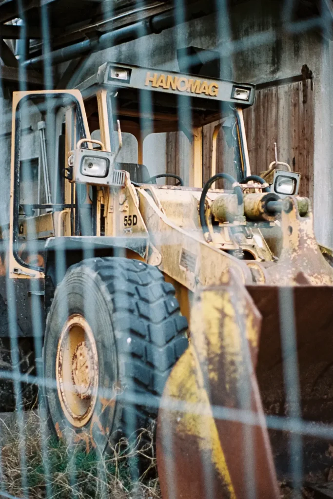 Decommissioned loader behind a fence at the machine boneyard.