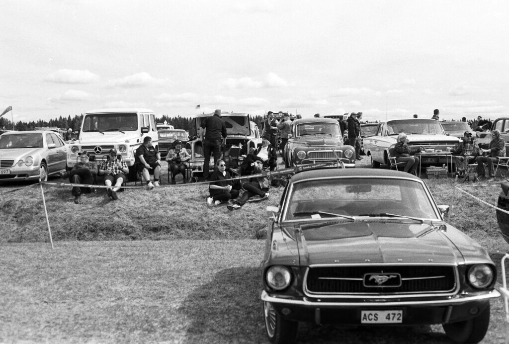 A picture of people beside a Ford Mustang