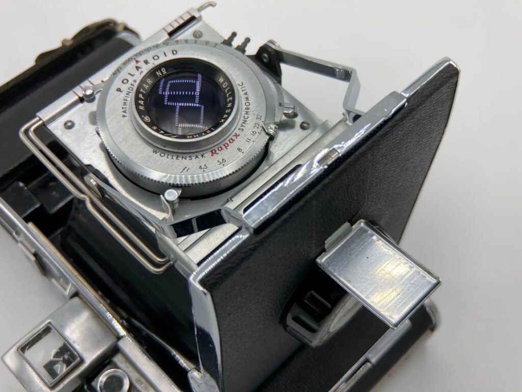 Closeup of the front, lens, and controls of a Polaroid Pathfinder 110 camera