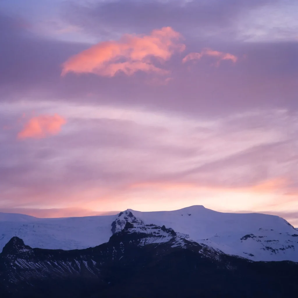 snow covered mountains and pink sky