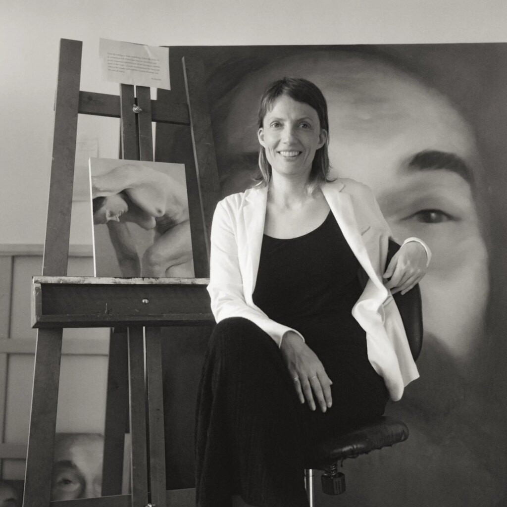 Portrait of an artist in studio with her paintings behind