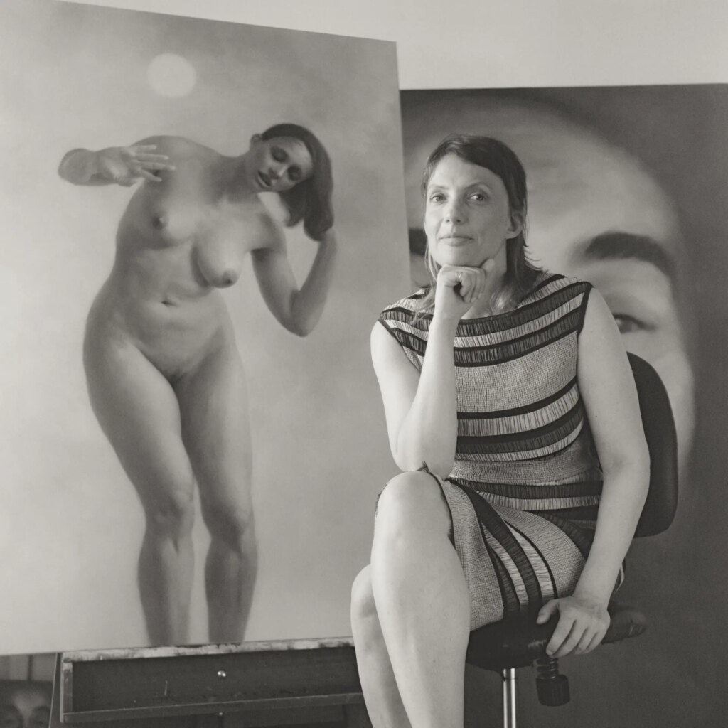 Portrait of an artist in studio with her paintings behind
