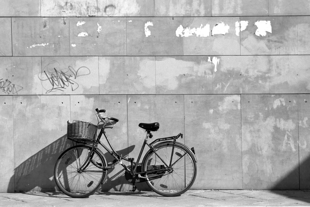 Photograph of a bike leaning against a tall cement wall