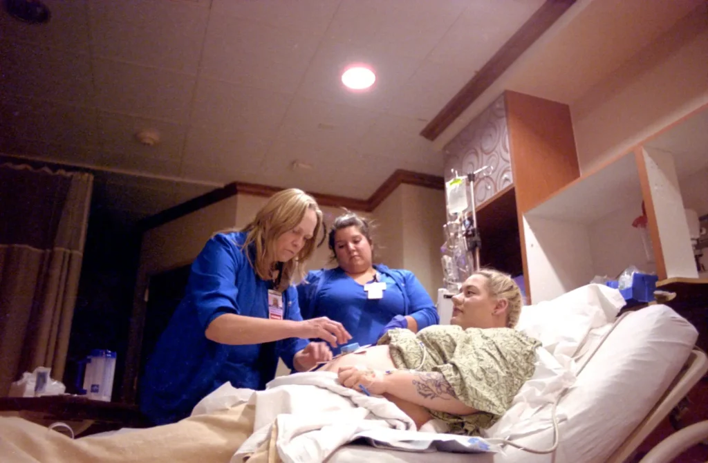 Nurses trying to get fetal heartbeat monitor to work