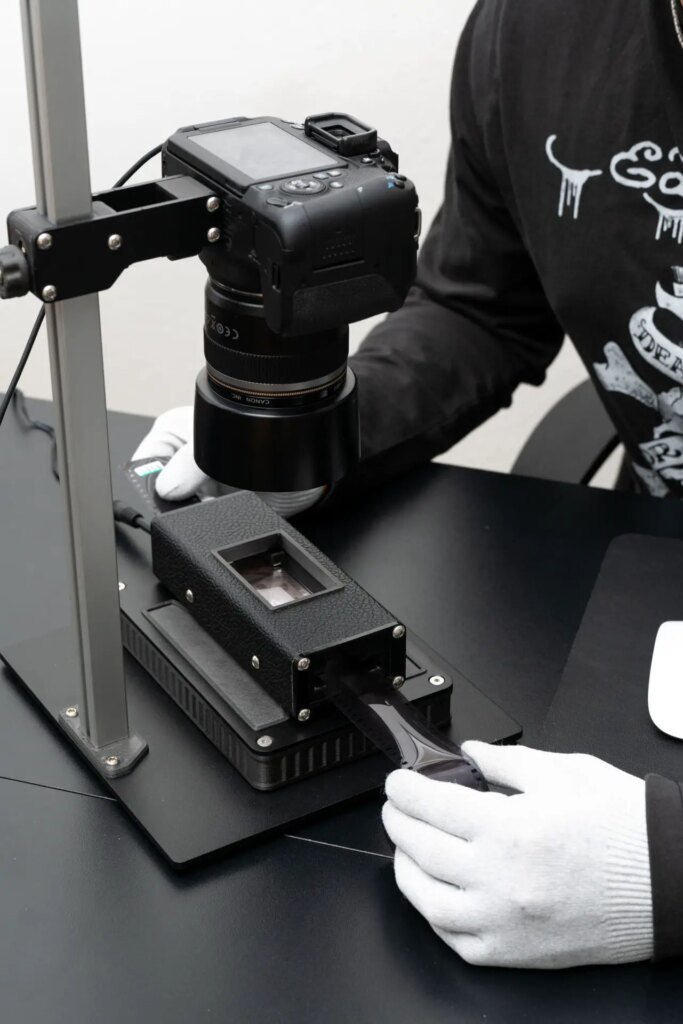 Full scanning set up with the light source mini 97 cri showing person sliding film through the negative carrier