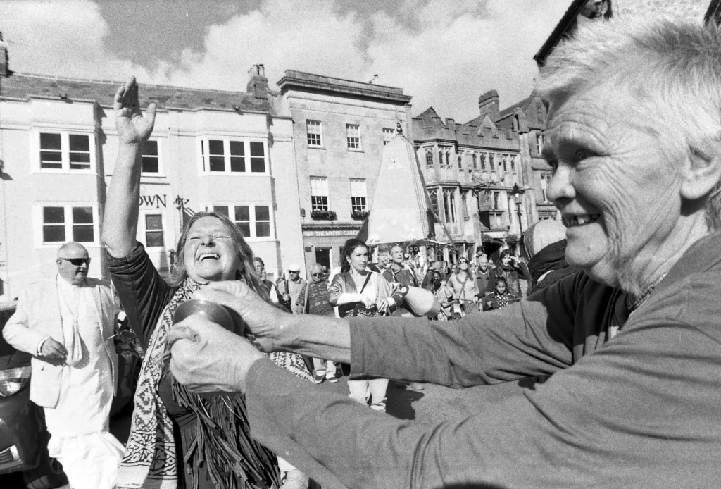 Devotees sing and dance through Glastonbury Highstreet, which itself is inundated with New Age shops.