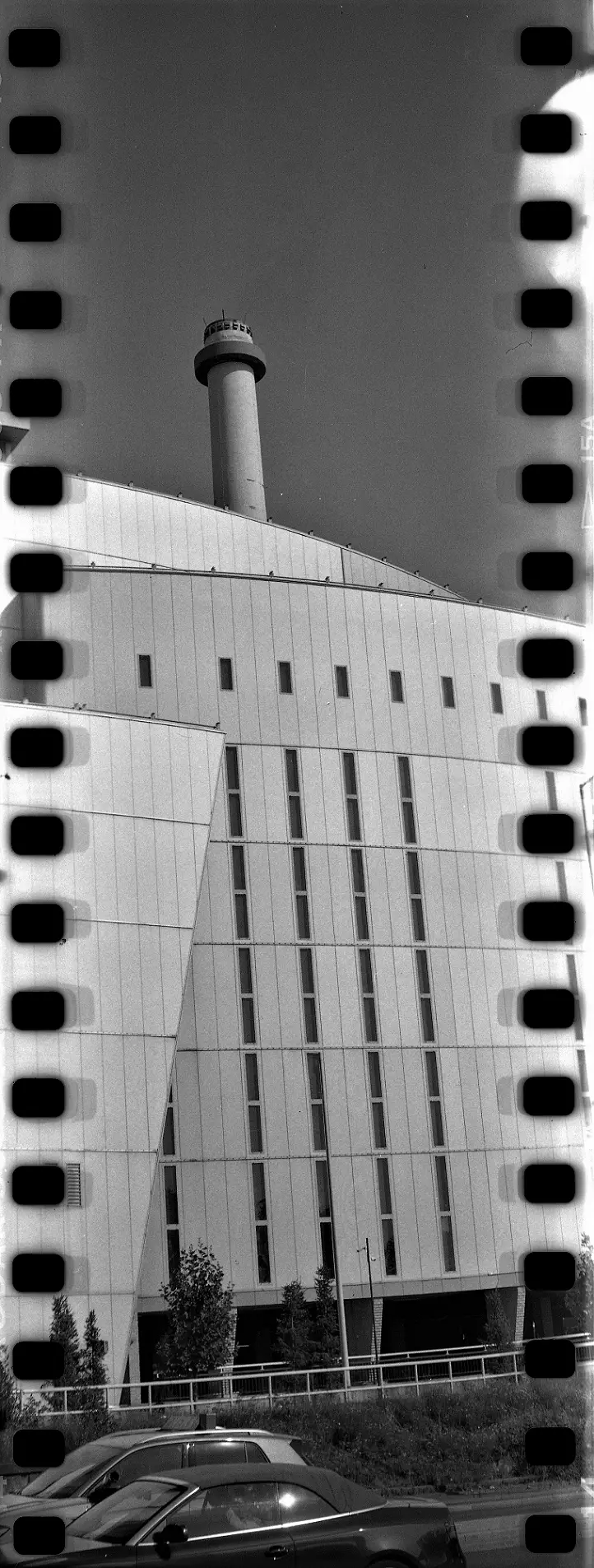 Vertical panorama of a tall industrial building with a chimney