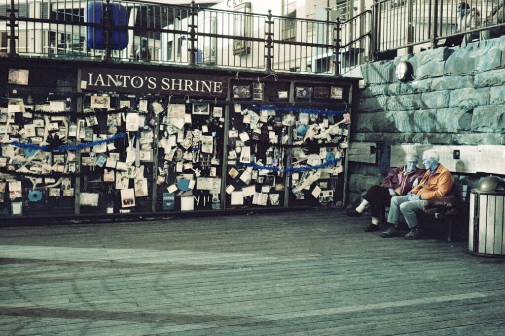A couple next to the Cardiff Bay shrine for a fictional character on the Leica CL