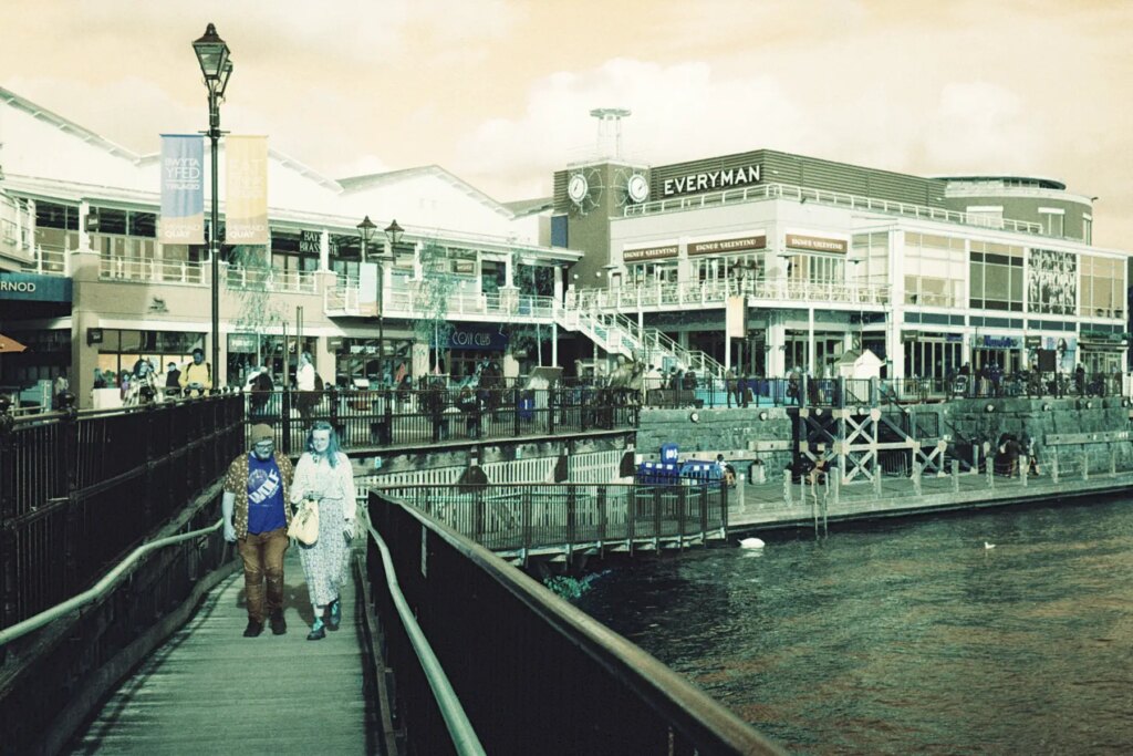 Couple walking along the boardwalk in the Cardiff Bay Marina shot on the Leica CL