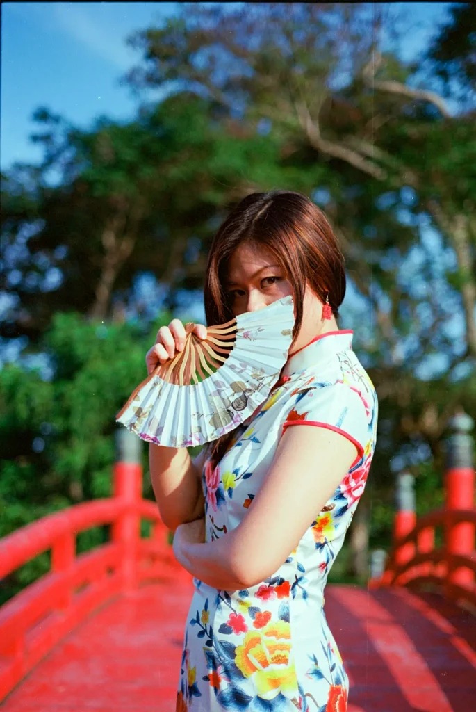 Portrait of woman holding fan shot with Contax G2 45mm Planar lens